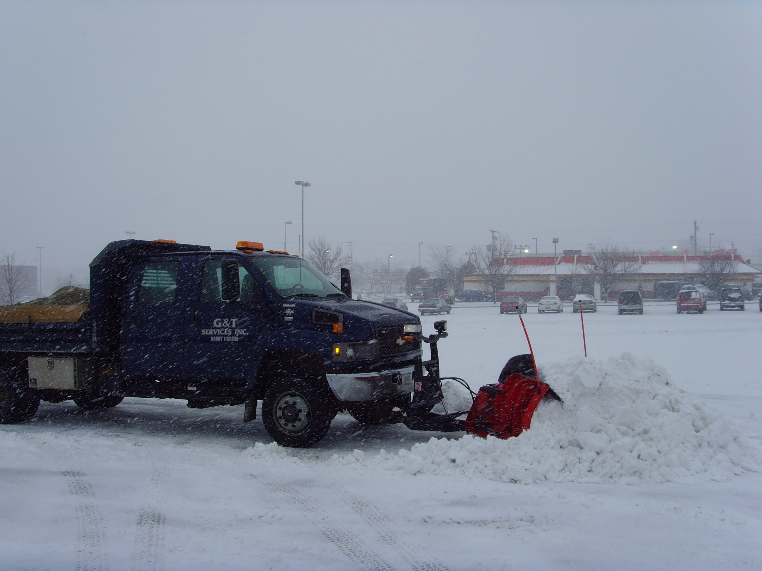 Truck with a plow pushing snow